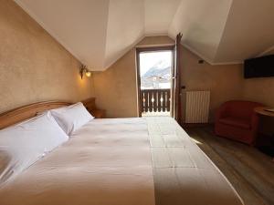 a bedroom with a large bed and a window at Hotel La Pastorella in Livigno