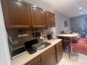 a kitchen with wooden cabinets and a sink at Charming Apartment with Jacuzzi Bathtub in La Chaux-de-Fonds