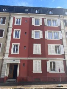 a red building with white windows and a door at Charming Apartment with Jacuzzi Bathtub in La Chaux-de-Fonds