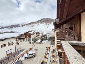 a balcony of a building with a car parked on the street at Hotel La Pastorella in Livigno