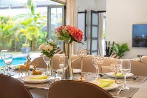 a dining room table with a vase of flowers on it at Nivara Pool Villa - Rawai in Rawai Beach