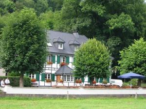 a large green and white house with people in front of it at Wißkirchen Hotel & Restaurant in Odenthal