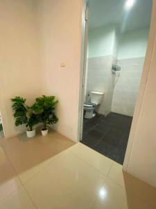 a bathroom with a toilet and a shower with two plants at Vera House in North Pattaya +8 photos