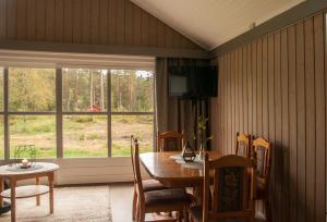 a dining room with a table and a window at 14 - Fulufjellets national parks-This is the place where Norway and Sweden meet in a large protected area for animals and nature in Trysil