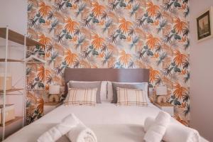 una camera da letto con un grande letto con carta da parati floreale di MELE flat a Valencia