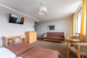 a bedroom with a bed and a desk and a couch at Rysy in Bukowina Tatrzańska