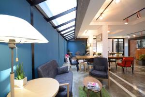 Cette chambre est dotée de tables, de chaises et de murs bleus. dans l'établissement Sunnyhill Hostel Hongdae, à Séoul