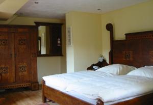 a bedroom with a large bed with a wooden headboard at Wißkirchen Hotel & Restaurant in Odenthal