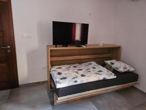 a bedroom with a bed with a tv on the wall at Mark & Lana in Sežana