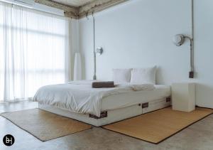 a bedroom with a large bed with white sheets at BAAN650 Hostel in Hat Yai
