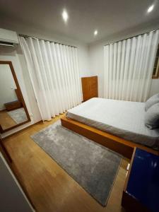 a bedroom with a bed and a desk with a laptop at Casa Encosta do Marao in Amarante +29 photos