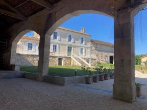 an archway in front of a building with potted plants at Le BRISSONNEAU in Saint-Saturnin