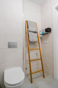 a wooden ladder next to a toilet in a bathroom at Apartamenty Mazurska Strefa in Pisz +7 photos