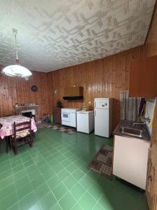 a kitchen with a green tiled floor and a table at Dai Nonni Vacation Home in Acciano
