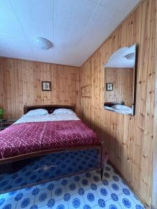 a bedroom with a bed in a room with wooden walls at Dai Nonni Vacation Home in Acciano