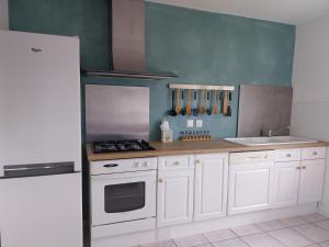 a kitchen with white cabinets and a white refrigerator at Le Dom'Mino in Condé-Folie +14 photos
