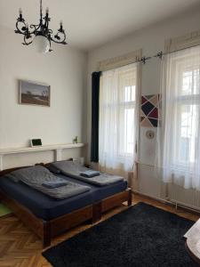 a bedroom with a bed and two windows at Lyrius Vendégház - Debrecen in Debrecen