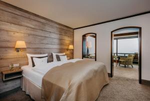 a bedroom with a large bed with a wooden wall at Waldhaus Ohlenbach in Schmallenberg