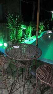 an outdoor table and chairs with a garden in the background at Pousada da Nani in São Gabriel