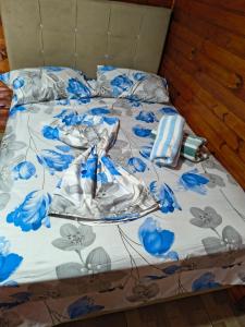 a bed with a blue and white comforter at Pousada da Nani in São Gabriel