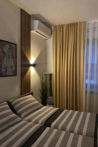 a bedroom with a bed and a window at Serana Stays Modern Rooms with Private Bathroom, Free WiFi & Parking, Central Pejë in Peje