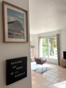a sign on a wall next to a living room at Aux Portes de La Roussille in Niort