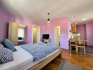 a bedroom with purple walls and a large bed at Apartman Gloria Sajam - Senjačka pijaca in Senjak (historical)