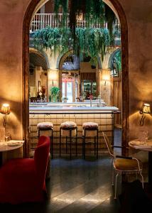 a restaurant with a bar with stools in a room at chic&basic Habana Hoose in Barcelona