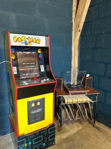 a colorful arcade video game machine next to a table at Gîte la plotuère in Gy-en-Sologne +41 photos