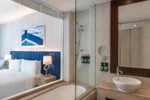 a bathroom with a bed and a bath tub and a sink at Crowne Plaza Yas Island by IHG in Abu Dhabi