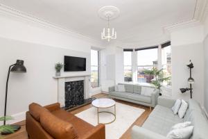 a living room with a couch and a fireplace at Detached House with Sea Views & Parking in North Berwick