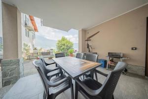 a table and chairs on a patio with a fireplace at Castelaus, Lake view, 1 Min Walk from the Lake in Dervio