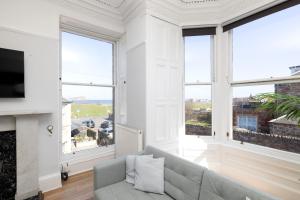 a living room with a couch and large windows at Detached House with Sea Views & Parking in North Berwick +46 photos