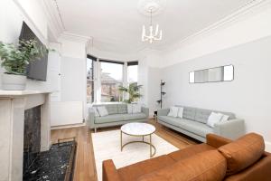 a living room with a couch and a fireplace at Detached House with Sea Views & Parking in North Berwick