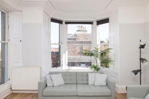 a living room with a couch and a large window at Detached House with Sea Views & Parking in North Berwick