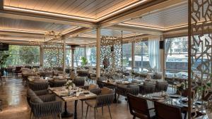 a restaurant with tables and chairs and large windows at Hotel Zodiac by Sofra in Constanţa