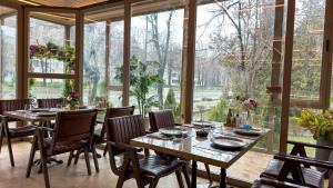 a dining room with tables and chairs and a large window at Hotel Zodiac by Sofra in Constanţa