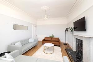 a living room with a couch and a fireplace at Detached House with Sea Views & Parking in North Berwick