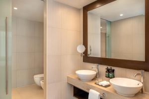 a bathroom with two sinks and a mirror at Crowne Plaza Yas Island by IHG in Abu Dhabi +79 photos
