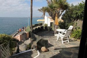 a patio with a table and chairs and the ocean at Estupendo bungalow cerca del mar in Maspalomas