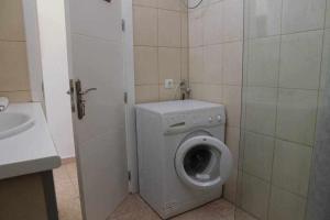 a small bathroom with a washing machine and a sink at Estupendo bungalow cerca del mar in Maspalomas