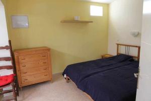 a bedroom with a blue bed and a wooden dresser at Estupendo bungalow cerca del mar in Maspalomas