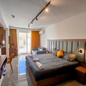 a bedroom with a large bed and a living room at The Black Onyx in Il-Gżira
