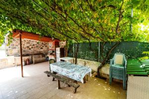 a patio with chairs and a table and a tree at Stefanidis studios in Stavros +3 photos