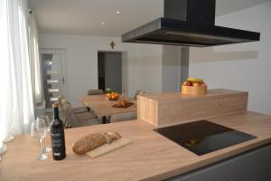 a kitchen with a table with a bottle of wine and bread at Pax et Bonum in Lozovac +17 photos