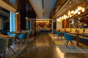 a restaurant with tables and chairs and a bar at DoubleTree by Hilton Hotel Riyadh - Al Muroj Business Gate in Riyadh