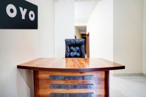 a wooden desk with a black chair in a room at Hotel O Hotel Denmark in Chinhat