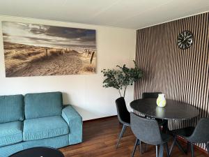 a living room with a couch and a table at Wellness in de NATUUR in Neede