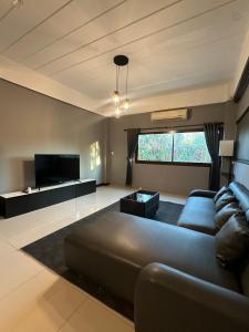 a living room with a couch and a tv at Vera House in North Pattaya
