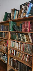 a bunch of books sitting on wooden shelves at Casa belgrano Lobos in Lobos